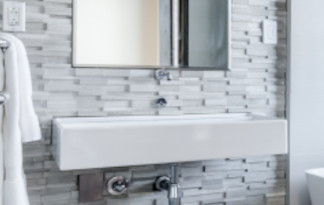 In der Nähe vom Waschbecken werden am besten wasserabweisende Materialien verbaut Bild: Spülbecken mit Wand ohne Fliesen